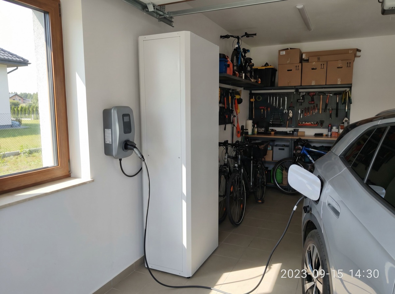 Magazyn energii w garażu domu jednorodzinnego obok ładowarki do auta elektrycznego